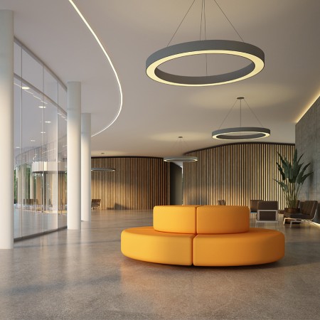 Moderner Empfangsbereich mit Designbodenbelag, runden Deckenleuchten und einer orangefarbene Sitzbank