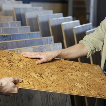 Korkbodenplatte wird von Verkäufer in der Bodenbelagsabteilung geprüft